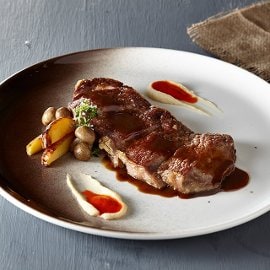 Αντρεκότ με καραμελωμένα κρεμμύδια και πουρέ μαϊντανού σε σάλτσα μαύρης μπίρας